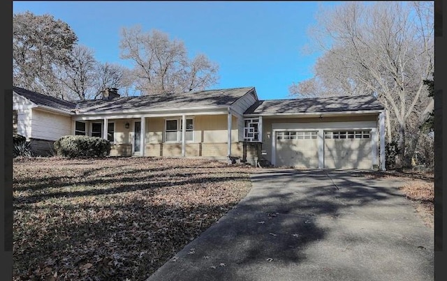 ranch-style home featuring covered porch and a garage