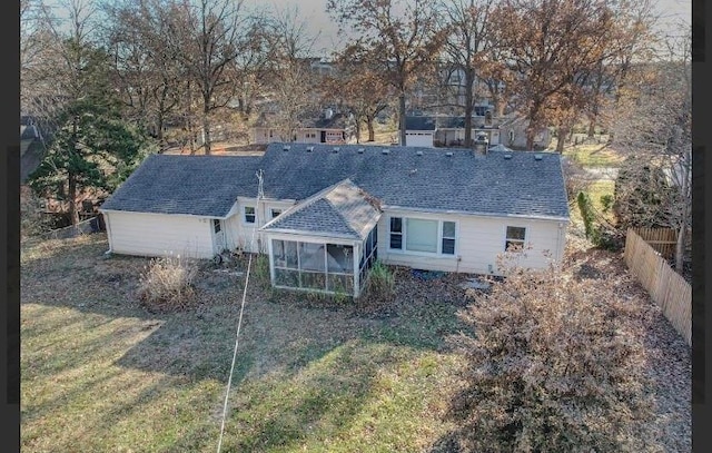 rear view of house with a sunroom and a lawn