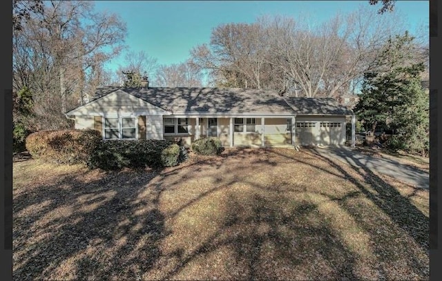 ranch-style house with a garage and a front lawn