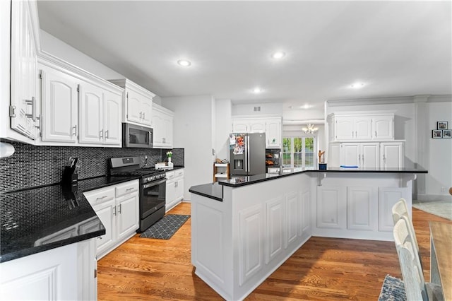 kitchen featuring decorative backsplash, light wood-type flooring, stainless steel appliances, and white cabinetry