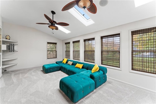 living room featuring ceiling fan, vaulted ceiling with skylight, and carpet floors