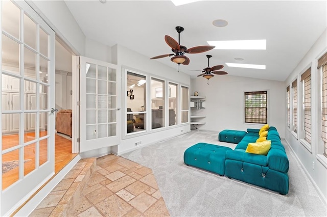 interior space with ceiling fan and vaulted ceiling with skylight