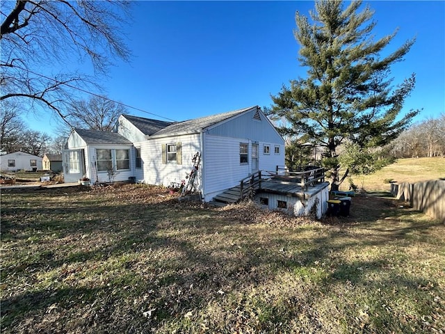 view of side of property featuring a lawn and a deck