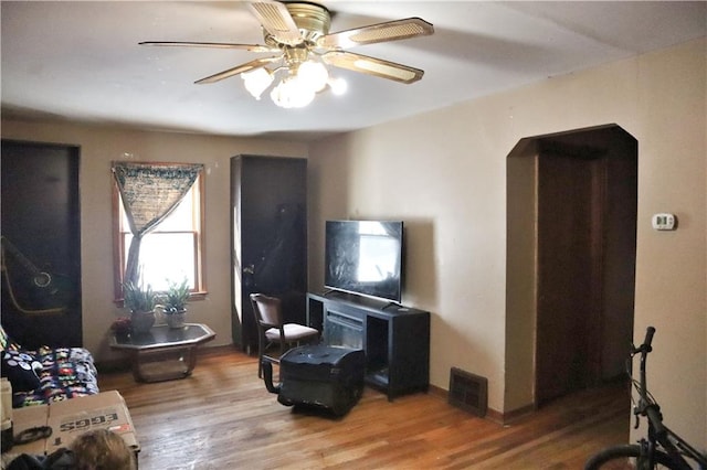 living room featuring ceiling fan and wood-type flooring