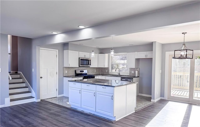 kitchen featuring white cabinetry, hanging light fixtures, stainless steel appliances, and sink