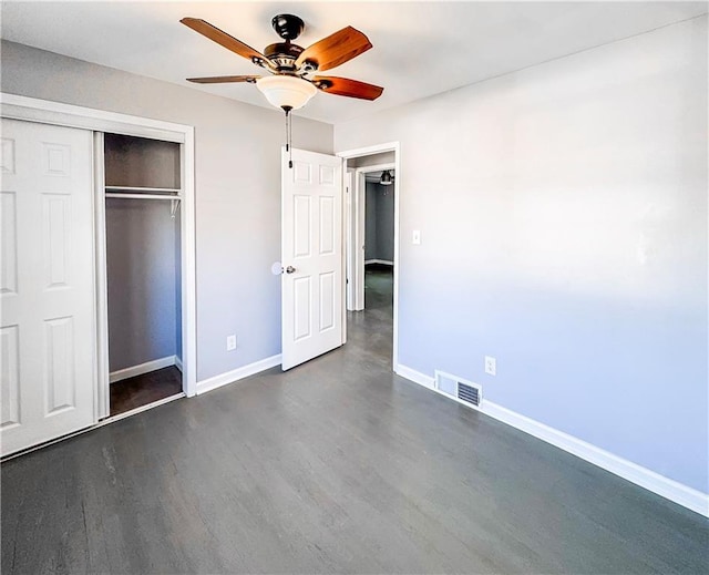 unfurnished bedroom featuring a closet, ceiling fan, and dark wood-type flooring