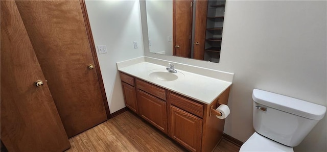 bathroom with hardwood / wood-style floors, vanity, and toilet