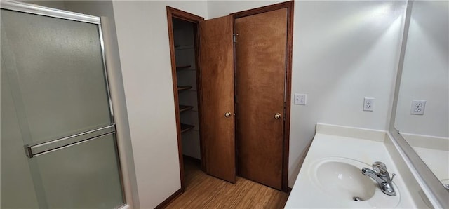 bathroom featuring a shower with door, vanity, and wood-type flooring