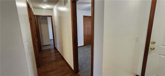 hall with dark colored carpet