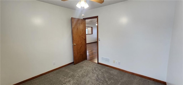 unfurnished room with ceiling fan and carpet