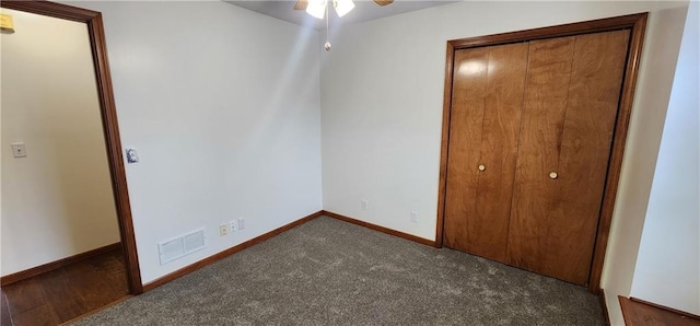 unfurnished bedroom featuring ceiling fan and dark carpet