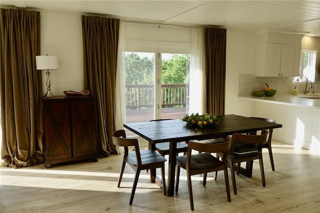 dining space with light hardwood / wood-style floors and sink