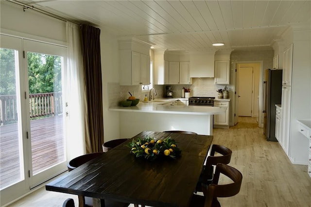 dining space with sink, wood ceiling, and light wood-type flooring