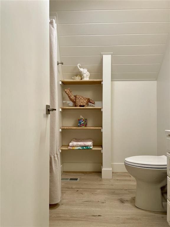 bathroom featuring hardwood / wood-style flooring and toilet