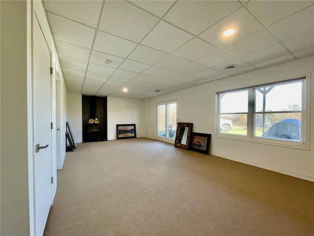 basement with a paneled ceiling and carpet floors