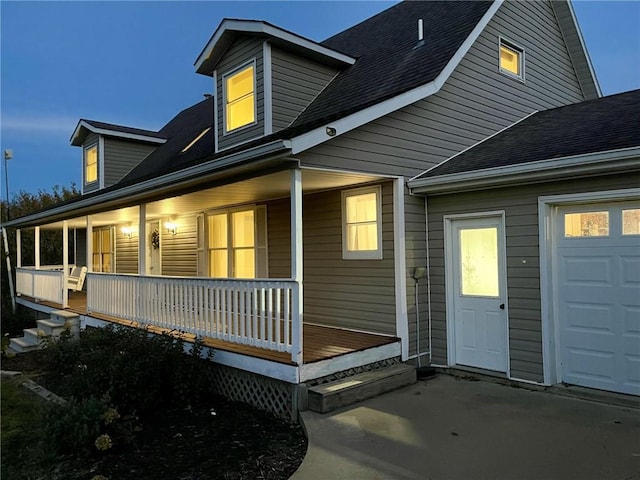 view of side of property with a porch and a garage