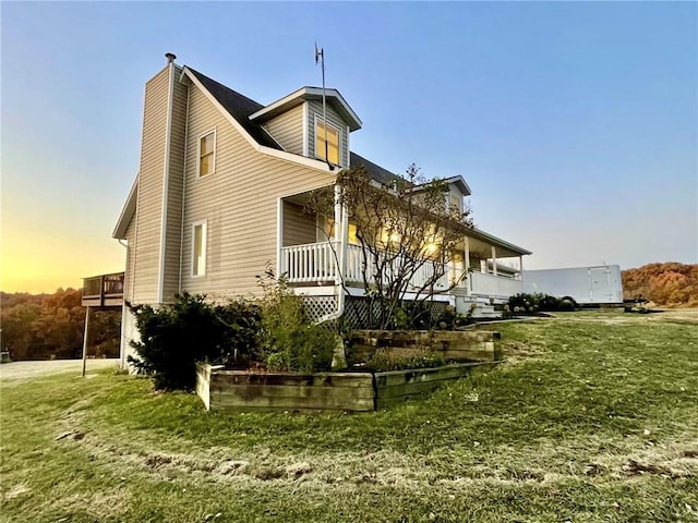 property exterior at dusk featuring a lawn