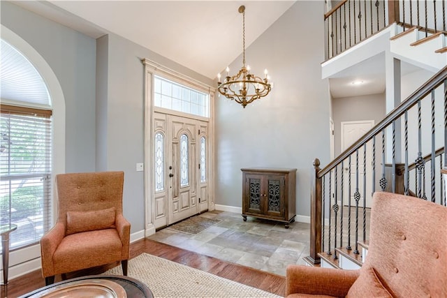 6764 Longview Rd, Shawnee, KS 66218 - foyer featuring high vaulted ceiling, baseboards, healthy amount of natural light, stairs, and a chandelier