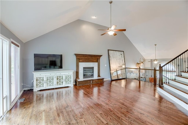 6764 Longview Rd, Shawnee, KS 66218 - unfurnished living room with a ceiling fan, a tile fireplace, plenty of natural light, wood finished floors, and high vaulted ceiling