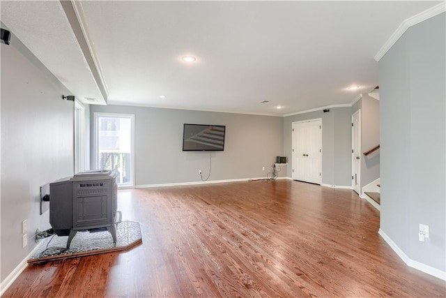 6764 Longview Rd, Shawnee, KS 66218 - unfurnished living room featuring a wood stove, wood finished floors, ornamental molding, stairway, and baseboards