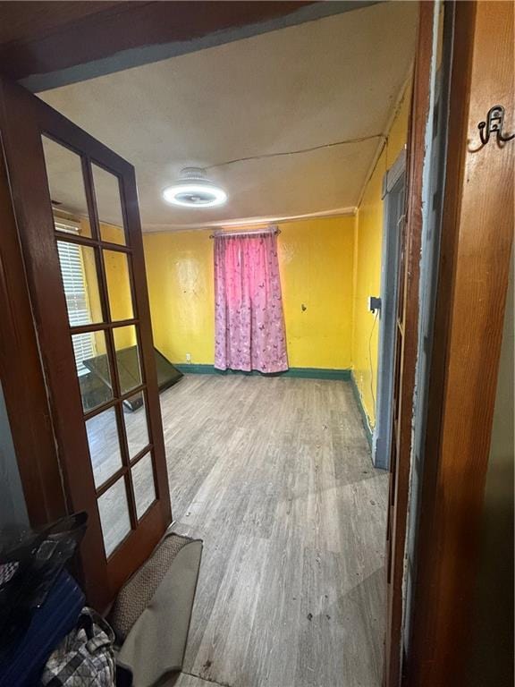 spare room featuring hardwood / wood-style floors and french doors