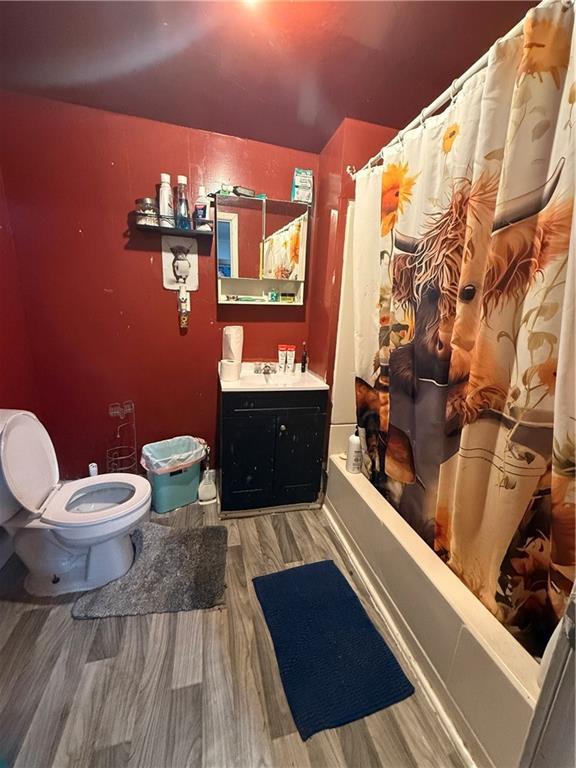 full bathroom featuring vanity, toilet, wood-type flooring, and shower / tub combo