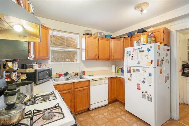 kitchen with range hood, white appliances, and sink