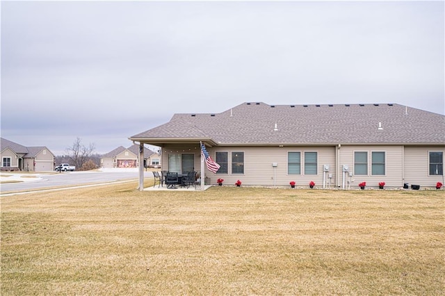 rear view of property featuring a yard and a patio