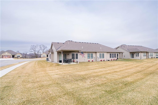 rear view of property with a yard and a patio area