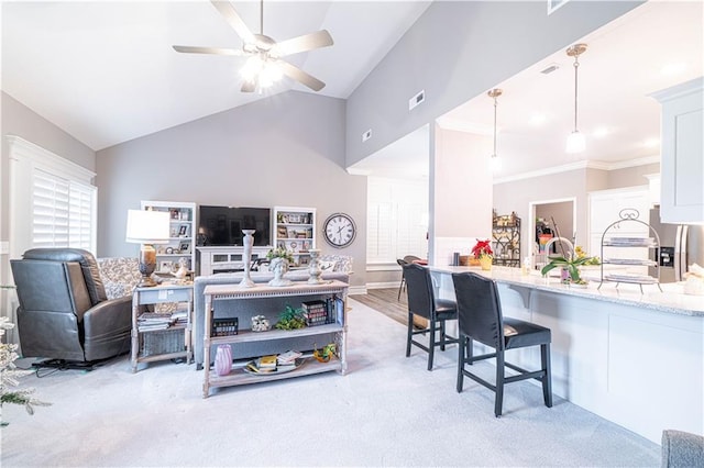 living room featuring ceiling fan, light carpet, vaulted ceiling, and ornamental molding