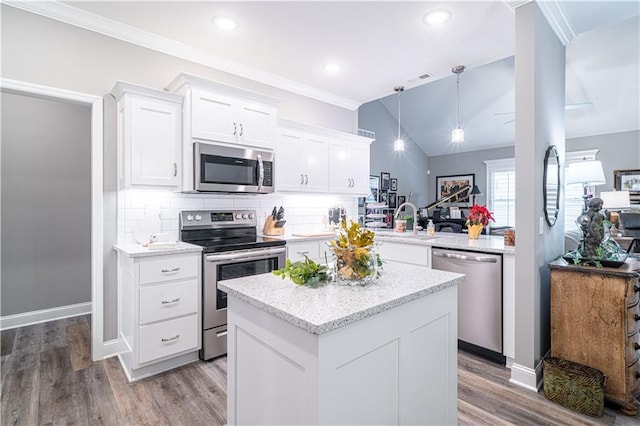 kitchen featuring white cabinets, decorative backsplash, appliances with stainless steel finishes, decorative light fixtures, and kitchen peninsula