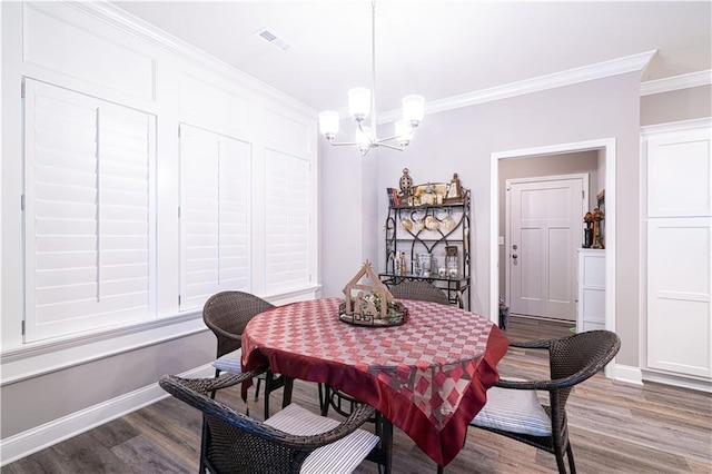 dining room with crown molding, a chandelier, and dark hardwood / wood-style floors