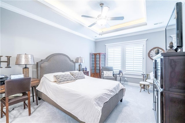 bedroom with a raised ceiling, ceiling fan, crown molding, and light colored carpet