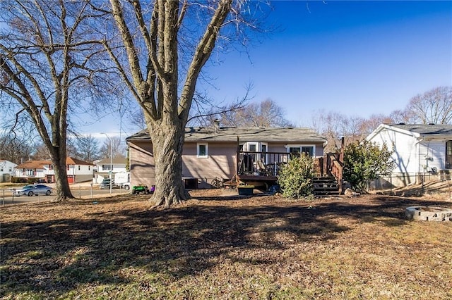 back of house with a deck and fence