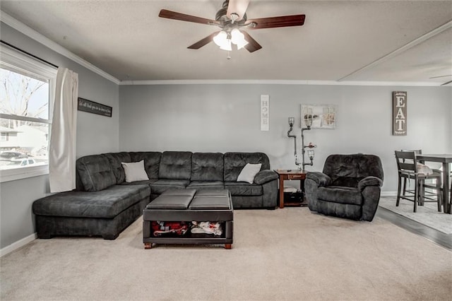 living room with carpet, crown molding, baseboards, and ceiling fan