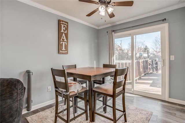 dining room with baseboards, crown molding, and wood finished floors