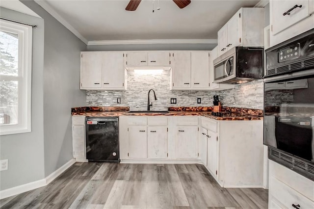 kitchen with a sink, white cabinetry, ornamental molding, black appliances, and tasteful backsplash