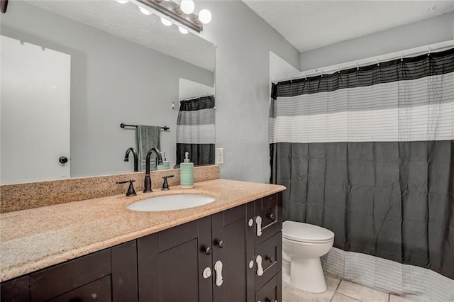 full bath featuring vanity, tile patterned flooring, and toilet