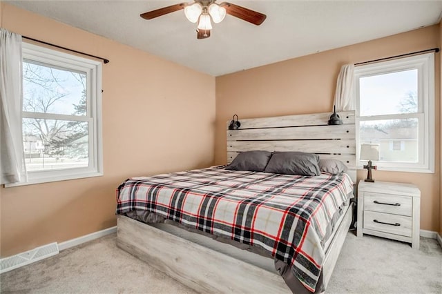 bedroom with baseboards, visible vents, and light colored carpet