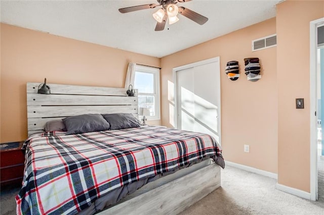 bedroom with ceiling fan, carpet flooring, visible vents, baseboards, and a closet