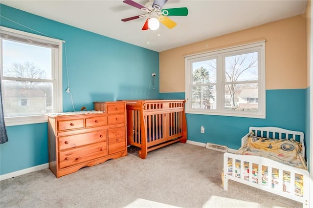 bedroom with carpet, visible vents, and multiple windows