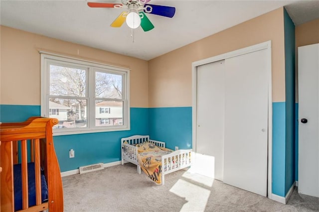 bedroom with light carpet, a closet, visible vents, and baseboards