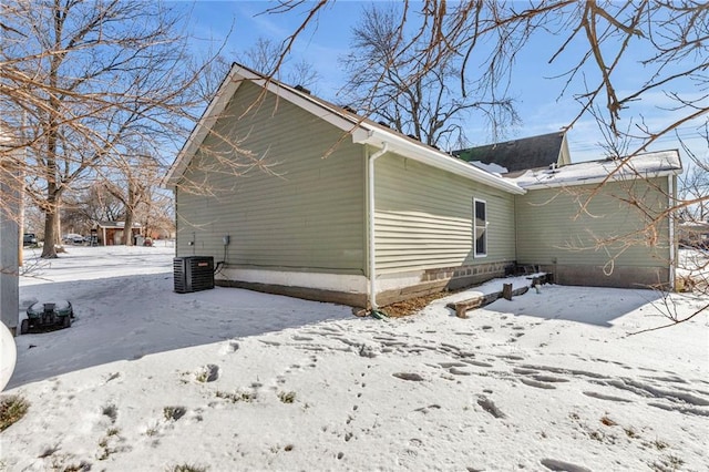 snow covered property featuring central AC