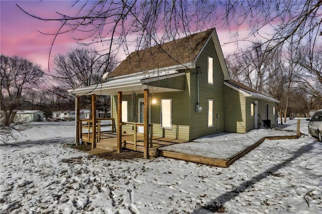 view of snowy exterior featuring covered porch