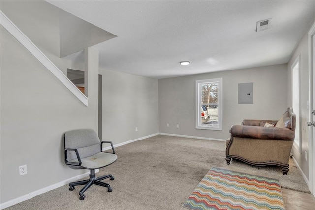 living area featuring light carpet and electric panel