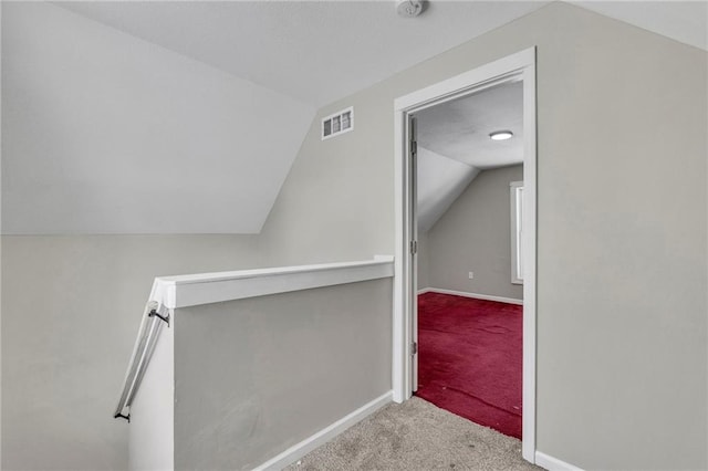 interior space featuring lofted ceiling and light colored carpet