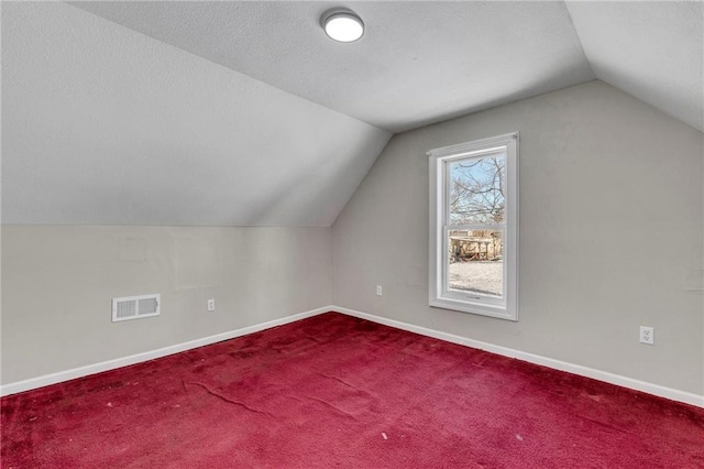 additional living space featuring lofted ceiling and carpet