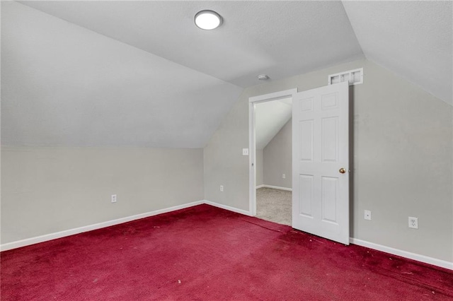 additional living space with carpet flooring and vaulted ceiling