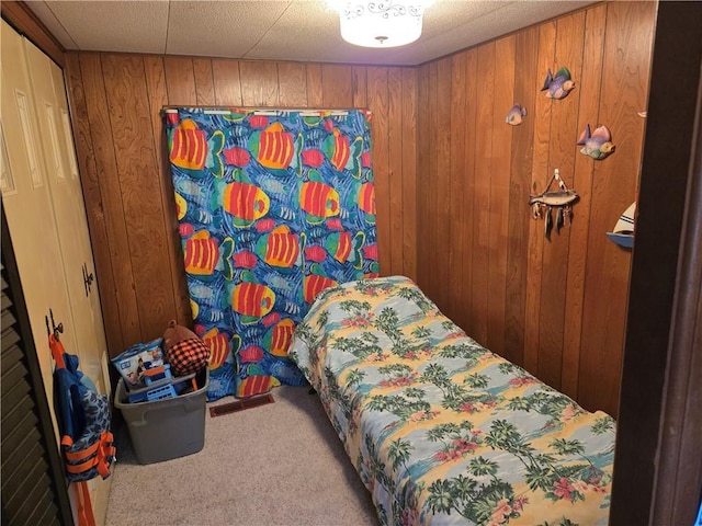 bedroom with carpet flooring and wood walls