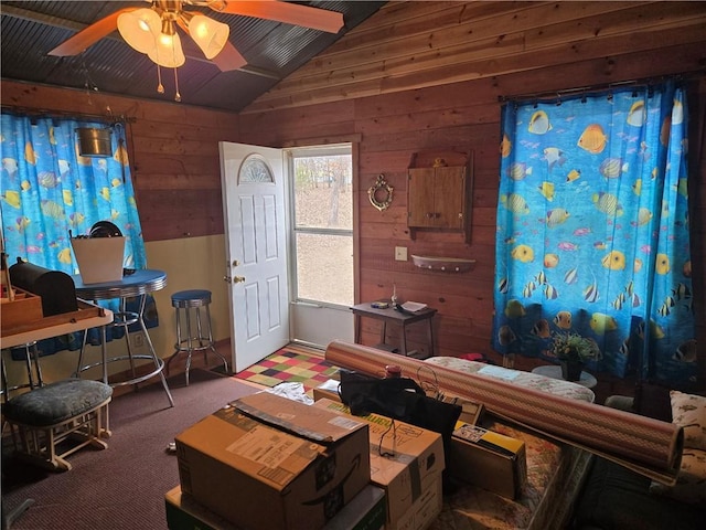 miscellaneous room with carpet flooring, ceiling fan, lofted ceiling, and wooden walls